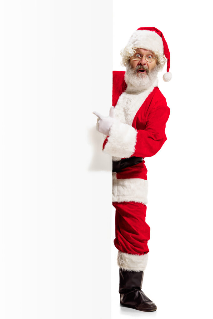 Happy Santa Claus pointing on blank advertisement banner background with copy space. Smiling Santa Claus pointing in white blank sign